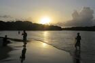 Fishermen at sunset in November 2015 along the freshwater lagoon in Tela, Honduras. (CNS photo) 
