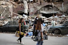 Women walk past destroyed cars at a neighborhood near the scene of Tuesday's explosion that hit the seaport of Beirut, Lebanon, Friday, Aug. 7, 2020. Rescue teams were still searching the rubble of Beirut's port for bodies on Friday, nearly three days after a massive explosion sent a wave of destruction through Lebanon's capital. (AP Photo/Thibault Camus)