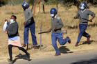 Zimbabwe riot police break up a protest for better pay and personal protective equipment by nurses in Harare in July. (AP photo/Tsvangirayi Mukwazhi)