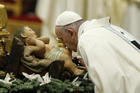 Pope Francis kisses a figurine of the baby Jesus at the start of Mass on the feast of Mary, Mother of God, in St. Peter's Basilica at the Vatican Jan. 1, 2020. (CNS photo/Paul Haring) 