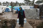 A woman carries bottles of water at a temporary camp for refugees on the island of Lesbos, Greece, Feb. 6, 2020. (CNS photo/Elias Marcou, Reuters) 