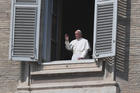 Pope Francis is seen in a window greeting a few nuns standing in St. Peter's Square at the Vatican March 22, 2020, after reciting his weekly Angelus prayer from the library of the Apostolic Palace. (CNS photo/Alberto Lingria, Reuters)