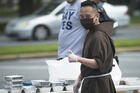 Capuchin Franciscan Brother Andrew Corriente hands out food to those in need in Washington, D.C., on May 19. Staff from the Archdiocese of Washington's Catholic Charities and volunteers distributed 800 boxes of food outside the Basilica of the National Shrine of the Immaculate Conception. (CNS photo/Tyler Orsburn)