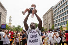 A man in Washington holds up a child during a protest against racial inequality June 6, 2020. Demonstrations continue after a white police officer in Minnesota was caught on a bystander's video May 25 pressing his knee into the neck of George Floyd, an African American, who was later pronounced dead at a hospital. (CNS photo/Eric Thayer, Reuters) 