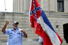 An employee at the Mississippi Capitol raises and lowers a commemorative state flag June 30, 2020, a flag that is purchased by people from all around the world. Hours later, Mississippi Gov. Tate Reeves signed a bill into law to replace the current state flag, which includes the Confederate emblem. (CNS photo/Suzi Altman, Reuters) 