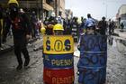 Anti-government protesters hide behind makeshift shields during clashes with the police in Bogota, Colombia, Wednesday, June 9, 2021. The protests have been triggered by proposed tax increases on public services, fuel, wages and pensions. (AP Photo/Ivan Valencia)