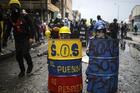 Anti-government protesters hide behind makeshift shields during clashes with the police in Bogota, Colombia, Wednesday, June 9, 2021. The protests have been triggered by proposed tax increases on public services, fuel, wages and pensions. (AP Photo/Ivan Valencia)