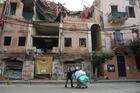 A woman wearing a protective masks pushes a cart past damaged buildings in Beirut Jan. 26, 2021, during the COVID-19 pandemic. More than half of the population of Lebanon lives in poverty. (CNS photo/Mohamed Azakir, Reuters)