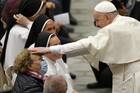 Pope Francis greets a woman during his general audience in the Paul VI hall at the Vatican Nov. 10, 2021.