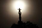 statue of our lady of sheshan atop a minor basilica, the sun is behind the statue