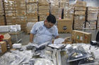 Claudio Montes checks a shipping manifest for U.S. manufactured parts heading to assembly plants in Mexico at Freight Dispatch Service Agency LTD in Pharr, Texas in June 2017. The freight service ships parts between the U.S. and Mexico that pass through the border freely due to the North American Free Trade Agreement. (Nathan Lambrecht/The Monitor via AP, File)