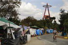 A cyclist passes the row of tents and tarps along the Santa Ana riverbed near Angel Stadium on Sept. 14 in Anaheim, Calif. Amid an uproar from residents, the city of Anaheim declared an emergency in an attempt to cope with a ballooning homeless encampment along a popular riverbed trail and speed the addition of shelter beds. (AP Photo/Jae C. Hong)