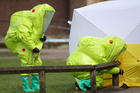 Personnel in hazmat suits work to secure a tent over the bench in Salisbury where former Russian double agent Sergei Skripal and his daughter Yulia were found critically ill by exposure to a nerve agent on March 4. (Andrew Matthews/PA via AP)