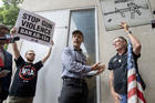 National Rifle Association member Jim Whelan, center, talks with protester David Lyles, right, outside the NRA Annual Meeting on May 4 in Dallas. (AP Photo/Jeffrey McWhorter)