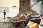 Michael Osborne, a film director, documents the damage from a mud slide next to his home in Los Angeles on Jan. 18, after three days of heavy rain. (AP Photo/Damian Dovarganes)