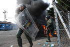 Officers of the Bolivarian National Guard clash with residents who cleared a barricaded border bridge attempting to bring humanitarian aid into the country, in Urena, Venezuela, near the border with Colombia, on Feb. 23. (AP Photo/Rodrigo Abd, File)
