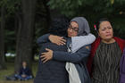 Mourners hug on March 18 after visiting the Masjid Al Noor mosque in Christchurch, New Zealand, the site of a terrorist attack last Friday. (AP Photo/Vincent Yu)