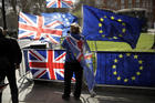 An anti-Brexit supporter stands by European and British Union flags placed opposite the Houses of Parliament in London, on March 18. (AP Photo/Matt Dunham)