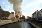 Notre Dame cathedral is burning in Paris, Monday, April 15, 2019. Massive plumes of yellow brown smoke is filling the air above Notre Dame Cathedral and ash is falling on tourists and others around the island that marks the center of Paris. (AP Photo/Lori Hinant)