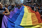 Revelers carry a rainbow flag along Fifth Avenue during the L.G.B.T. Pride Parade in New York on June 24, 2018. (AP Photo/Andres Kudacki, File)