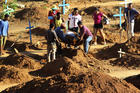 People bury a prisoner who was killed during a prison riot in Altamaria, Para state, Brazil, on July 31. Grieving families began to arrive that day at the cemetery of Altamira to mourn some of the 58 inmates killed by a rival gang in a grisly prison riot. (AP Photo/Raimundo Pacco)