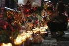 Roxana Jaquez lights a candle at an ever growing memorial Monday, Aug. 5, 2019, outside the Walmart in El Paso, Texas, where a mass shooting took place on Saturday. 