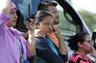 Friends, coworkers and family watch as U.S. immigration officials raid the Koch Foods Inc., plant in Morton, Miss., Wednesday, Aug. 7, 2019. U.S. immigration officials raided several Mississippi food processing plants on Wednesday and signaled that the early-morning strikes were part of a large-scale operation targeting owners as well as employees. (AP Photo/Rogelio V. Solis)
