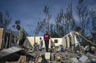 George Bolter, left, and his parents walk through the remains of his home destroyed by Hurricane Dorian in the Pine Bay neighborhood of Freeport, Bahamas, on Sept. 4. (AP Photo/Ramon Espinosa)