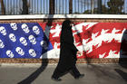 A mourner leaves a funeral ceremony for Iranian Gen. Qassim Soleimani and his comrades, passing graffiti on the wall of the former U.S. Embassy in Tehran, Iran, on Jan. 6. (AP Photo/Vahid Salemi)