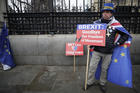 Anti-Brexit campaigner Steve Bray holds banners as he stands outside Parliament in London on Jan. 30, 2020. Although Britain formally leaves the European Union on Jan. 31, little will change until the end of the year. (AP Photo/Kirsty Wigglesworth)