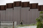 A border patrol agent walks along a wall separating Tijuana, Mexico, from San Diego on March 18. (AP Photo/Gregory Bull)