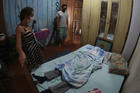 Relatives stand next to the body of Raimundo Costa do Nascimento, 86, at his home in Sao Jorge, Manaus, Brazil, on April 30. According to the family, Costa do Nascimento died of pneumonia and had to wait 10 hours for funerary services to come pick up his body. (AP Photo/Edmar Barros)