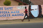 A young boy walks past a wall with graffiti urging people to wear face masks in Harare, on May 28. Manhunts have begun after hundreds of people fled quarantine centres in Zimbabwe and Malawi. Authorities worry they will spread COVID-19 in countries whose health systems can be rapidly overwhelmed. (AP Photo/Tsvangirayi Mukwazhi)