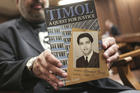 Imtiaz Cajee, nephew of Ahmed Timol, poses with his book about the activist on Aug. 24 in the North Gauteng High Court in Pretoria, South Africa. (AP Photo, File)