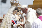 Pope Francis touches a statue of Mary and Jesus after crowning it during Mass at Lobito beach in Iquique, Chile, Jan. 18. (CNS photo/Paul Haring) 