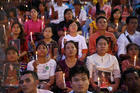 People hold photos of Myanmar state counselor Aung San Suu Kyi during an Oct. 10 candlelight interfaith prayer service in Yangon (CNS photo/Soe Zeya Tun, Reuters).