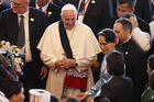 Pope Francis wears a gift as he arrives with Aung San Suu Kyi, state counselor and foreign minister of Myanmar, for a meeting with government authorities, members of civil society and the diplomatic corps at the Myanmar International Convention Center in Naypyitaw, Myanmar, Nov. 28. (CNS photo/Paul Haring)
