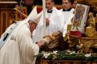 Pope Francis venerates a figurine of the baby Jesus as he celebrates Mass marking the feast of Mary, Mother of God, in St. Peter's Basilica at the Vatican Jan. 1. (CNS photo/Paul Haring) 