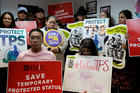 People hold signs during a news conference Jan. 8 at the New York Immigration Coalition in Manhattan following U.S. President Donald Trump's announcement to end the Temporary Protected Status for Salvadoran immigrants. (CNS photo/Andrew Kelly, Reuters) 