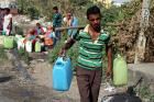 A man carries containers filled with drinking water after taking it from a public tap at a roadside in Jammu, India, May 23, 2016 (CNS photo/Jaipal Singh, EPA).