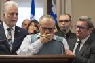 Mohamed Labidi, the vice-president of the mosque where an attack happened, is comforted by Quebec Premier Philippe Couillard, left, and Quebec City mayor Regis Labeaume, right, during a news conference on Jan. 30 about the fatal shooting at the Quebec Islamic Cultural Centre on Sunday. (Jacques Boissinot/The Canadian Press via AP)