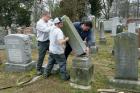 Rosenbloom Monument Co. workers from left, Nathan Fohne, Derek Doolin and Philip Weiss hoist a headstone at the Chesed Shel Emeth Cemetery in University City, Mo., where over 150 headstones were tipped over. (AP Photo/Jim Salter)