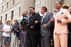 Local elected and religious leaders link arms in prayer, led by Father Eric Cruz, regional director of Catholic Charities Bronx, on the steps of the Bronx County Building in New York on June 22. (Photo: Allyson Escobar)
