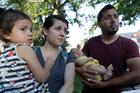 Pepe Urzua, a roofer who arrived from Mexico eight years ago, cradles his two-month-old daughter, Luna, as his wife, Betty, holds their daughter, Scarlet, during the a street festival in Goshen, Ind., on June 1, 2018. (AP Photo/Charles Rex Arbogast)