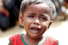 A Rohingya refugee child cries as others wait in line for aid Sept. 22 at a camp in Cox's Bazar, Bangladesh.