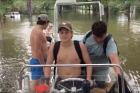 Declan Conner, center, steers his family's fishing boat through their flooded neighborhood outside Houston Aug. 27. (Screenshot via Mark Mulligan on Twitter)