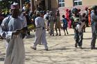 A security guard checks a handheld metal detector outside St. Hillary's Catholic Church in Maiduguri, Nigeria. Guards have intercepted suicide bombers attempting to enter the church compound. (Linus Unah)