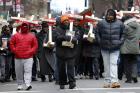 People carry crosses with names of victims of gun violence during a Dec. 31 march in downtown Chicago. Hundreds of people joined the march to remember those who died by gun violence in 2016 (CNS photo/Karen Callaway, Catholic New World).