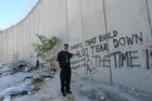 Retired Bishop Michael D. Pfeifer of San Angelo, Texas, stands in front of the Israeli separation wall near Jerusalem Sept. 12. Bishop Higgins was one of 18 bishops on a nine-day prayer pilgrimage for peace in the Holy Land. (CNS photo/Debbie Hill) 