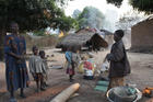 Women and children stand near their destroyed house in a village in Bossangoa, Central African Republic